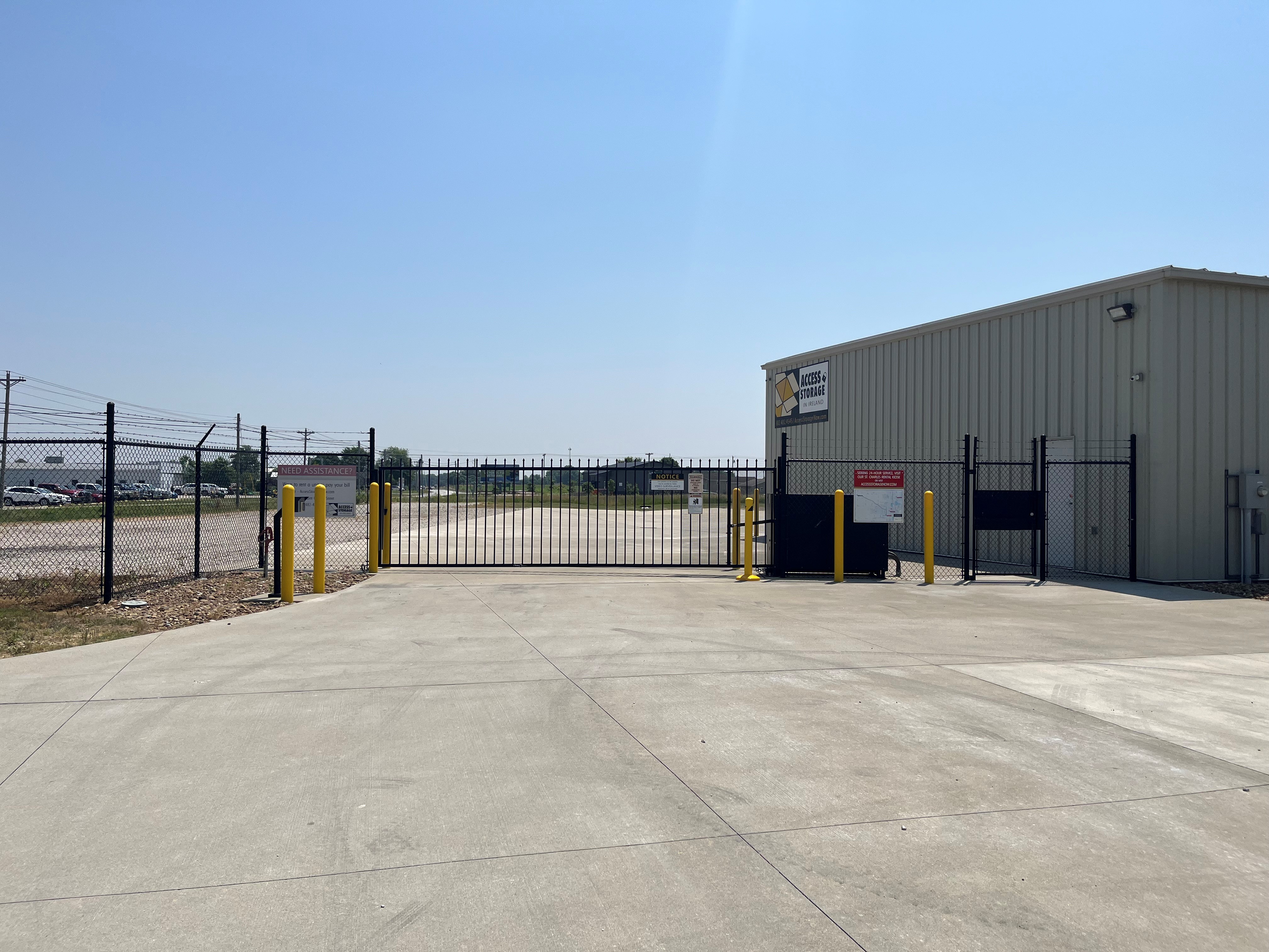Gated facility in Jasper, IN, offering enclosed parking units with white doors, expansive driveways, open parking, and kiosk services.